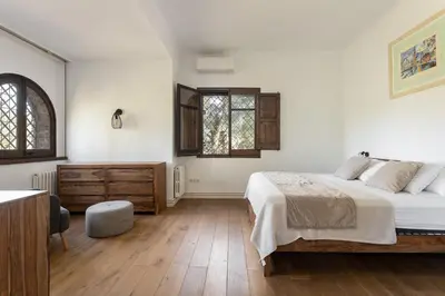 a white bedroom with a bed and a dresser at Luxury Villa El Turo in Castellví de Rosanés