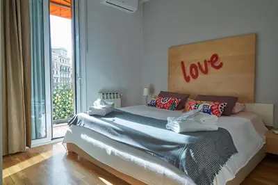 a bedroom with a bed with a love sign on it at Spacious & Comfortable flat in centric Eixample in Barcelona
