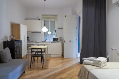 a small apartment with a kitchen and a table and chairs at Spacious & Comfortable flat in centric Eixample in Barcelona