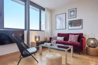 a living room with a red couch and a table at SibsBcn Downtown Penthouse in Barcelona