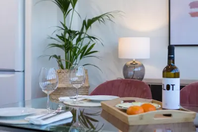a table with a bottle of wine and two wine glasses at SibsBcn Downtown Penthouse in Barcelona