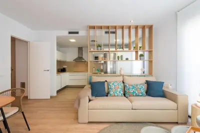 a living room with a couch and a kitchen at Sitges Centre. Simply Charming in Sitges