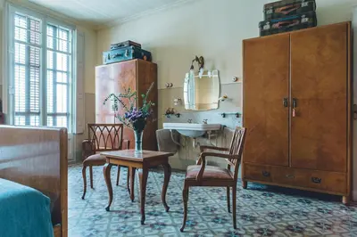 a bathroom with a sink and a table and chairs at Casa Baulenas in Caldes d'Estrac