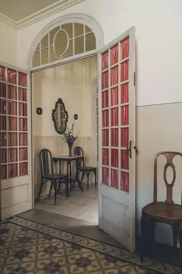 a room with a table and chairs and a door at Casa Baulenas in Caldes d'Estrac