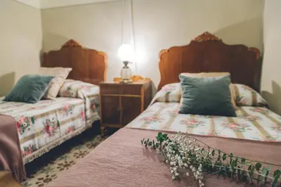 a bedroom with two beds and a table with a lamp at Casa Baulenas in Caldes d'Estrac
