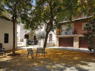 two chairs under a tree in front of a building at BLAU in Masnou