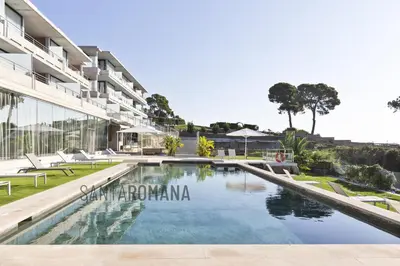 an image of a swimming pool in front of a building at Santa Romana Apartments & Suites in Caldes d'Estrac