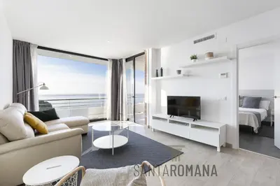 a white living room with a view of the ocean at Santa Romana Apartments & Suites in Caldes d'Estrac