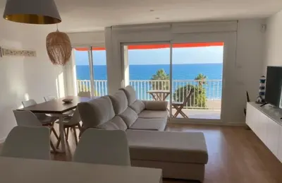 a living room with a couch and a table at Apartamento frente al mar in Canet de Mar
