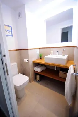 a bathroom with a white toilet and a sink at Apartamento frente al mar in Canet de Mar