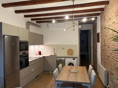 a kitchen with a wooden table and a brick wall at OLYMPIC VILLAGE in Barcelona