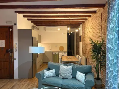 a living room with a blue couch and a kitchen at OLYMPIC VILLAGE in Barcelona