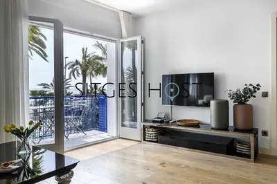 a living room with a tv and a large window at A 20 metros de la playa in Sitges
