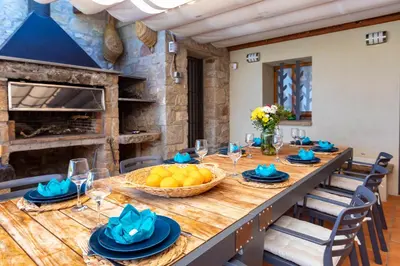 a dining room with a large wooden table with fruit on it at 21 Sleeps Private Pool Villa & BBQ Near Barcelona in Rocafort