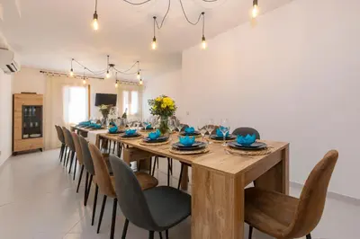 a dining room with a long wooden table and chairs at 21 Sleeps Private Pool Villa & BBQ Near Barcelona in Rocafort