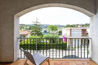 a room with a balcony with a chair at Villa Paquita in Calella