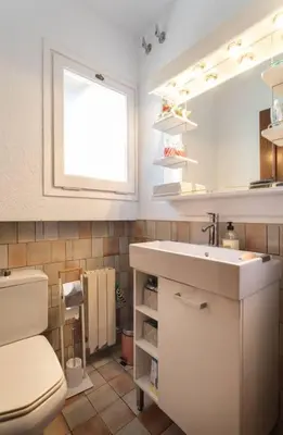 a bathroom with a sink and a toilet and a mirror at Villa Paquita in Calella