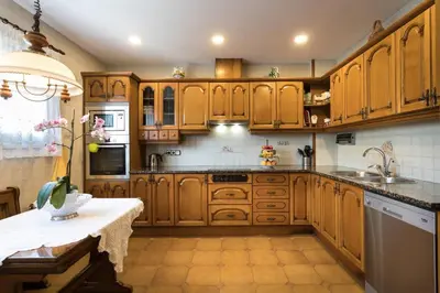 a kitchen with wooden cabinets and a sink at Villa Paquita in Calella