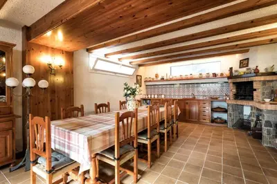 a large dining room with a wooden table and chairs at Villa Paquita in Calella