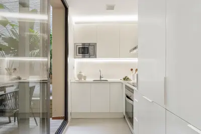 a kitchen with white cabinets and a sink at Ola Living Calabria in Barcelona