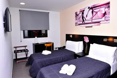 a hotel room with two beds and a tv at 6 Bis HOTEL in Castelldefels