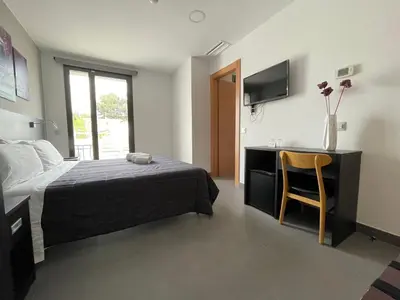 a bedroom with a bed and a desk and a chair at 6 Bis HOTEL in Castelldefels