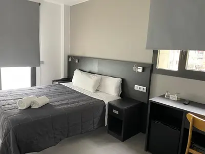 a hotel room with a bed and a desk at 6 Bis HOTEL in Castelldefels