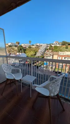 a balcony with a table and chairs and a view of a city at Arena Gold Euroviajeros apartaments in Pineda de Mar