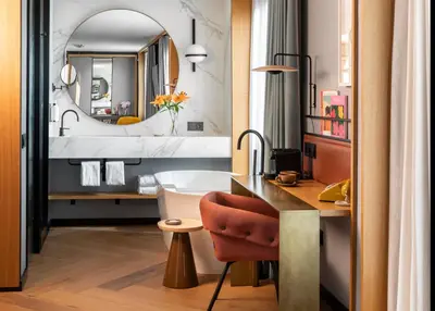 a bathroom with a sink and a desk with a tub at Kimpton Vividora Hotel by IHG in Barcelona