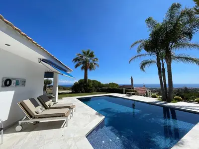 a villa with a swimming pool and palm trees at Palm Maresme - Suite with bathroom and terrasse with ocean views in a private villa in Vilassar de Dalt
