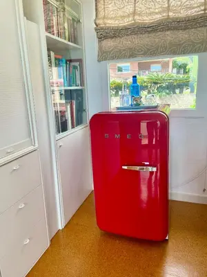 a red refrigerator in a room with a window at Palm Maresme - Suite with bathroom and terrasse with ocean views in a private villa in Vilassar de Dalt