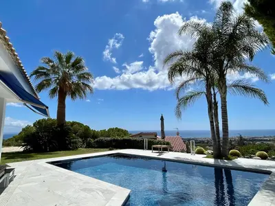 a swimming pool in a yard with palm trees at Palm Maresme - Suite with bathroom and terrasse with ocean views in a private villa in Vilassar de Dalt
