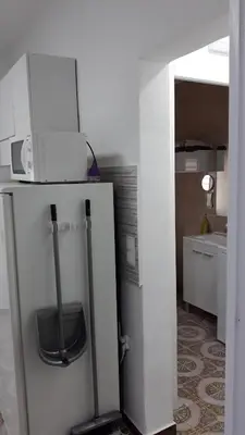 a white refrigerator with a microwave on top of it at loft turistic in San Vicente dels Horts