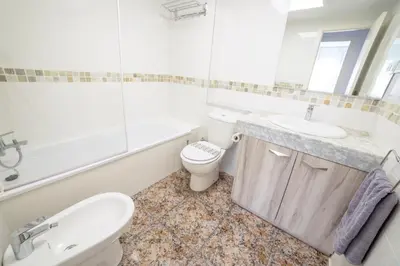 a white bathroom with a toilet and a sink at CUNIT HOME in Cunit