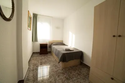 a small bedroom with a bed and a window at CUNIT HOME in Cunit