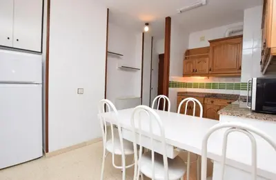a kitchen with a white table and white chairs at Apartamento Pineda in Pineda de Mar