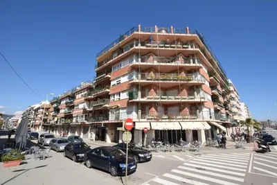 a tall building with cars parked in front of it at Apartamento Pineda in Pineda de Mar