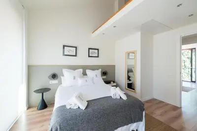 a bedroom with a large bed with towels on it at Petit Luxe Tobella Dreta in Terrassa