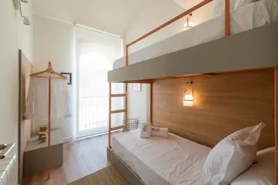 a bedroom with a bunk bed with a wooden headboard at Petit Luxe Tobella Dreta in Terrassa