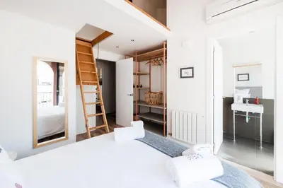 a small bedroom with a bed and a bathroom at Petit Luxe Tobella Dreta in Terrassa