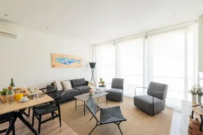 a living room with a couch and a table and chairs at Petit Luxe Tobella Dreta in Terrassa