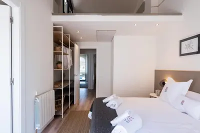 a bedroom with a white bed with towels on it at Petit Luxe Tobella Esquerra in Terrassa
