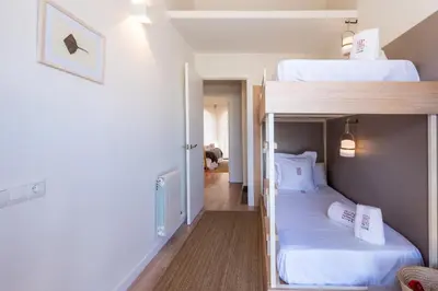 a room with two bunk beds and a hallway at Petit Luxe Tobella Esquerra in Terrassa