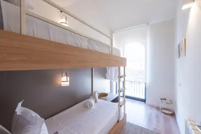 a bedroom with a bunk bed with white sheets at Petit Luxe Tobella Esquerra in Terrassa
