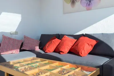 a blue couch with red pillows and a table at Key Sagrada Familia / MARINA 223 in Barcelona