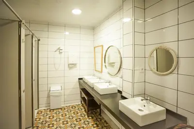 a bathroom with two sinks and two mirrors at Pars Tailor's Hostel in Barcelona