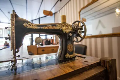 an old sewing machine sitting on top of a table at Pars Tailor's Hostel in Barcelona
