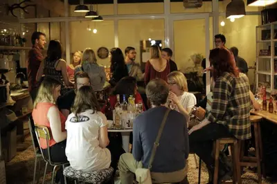 a group of people sitting around a table in a room at Pars Tailor's Hostel in Barcelona