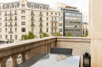 a table on a balcony with a view of buildings at Uma Suites Passeig de Gracia 16 in Barcelona
