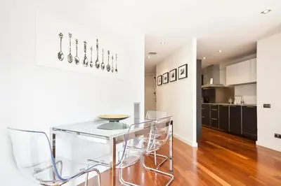 a dining room with a glass table and chairs at Uma Suites Passeig de Gracia 16 in Barcelona